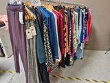 beaucoup de vêtements suspendus à une étagère dans un magasin