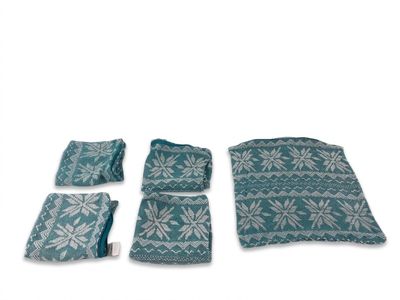 lot de quatre coussins tricotés bleu sarcelle et blancs, ainsi qu'une couverture