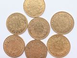 six different types of gold coins on a white surface