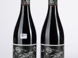 deux bouteilles de vin rouge posées l'une à côté de l'autre sur une table