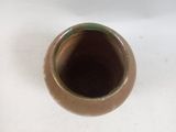 a small brown vase sitting on a white table