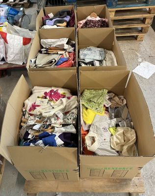 des cartons de vêtements posés sur une palette dans un entrepôt