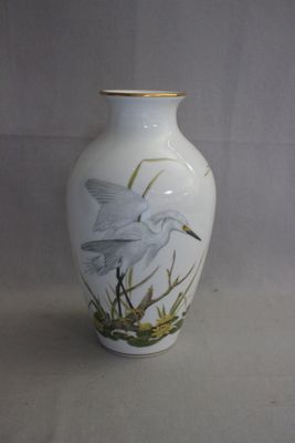 un vase blanc orné d'une peinture représentant un oiseau