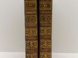 a pair of old books sitting on top of a white table