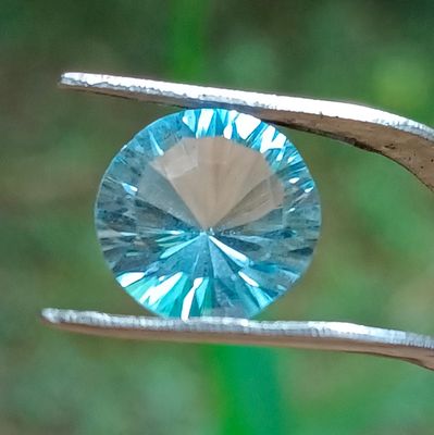 un gros plan d'un diamant bleu tenu par une pince