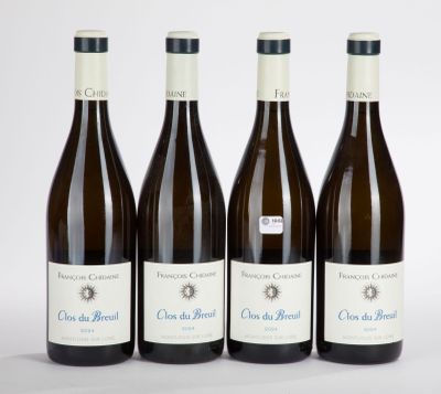 four bottles of wine are lined up on a white surface