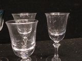 four wine glasses sitting on a table with a black background