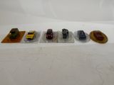 several toy cars are lined up on plastic trays on a white surface