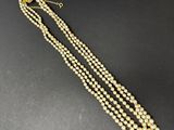 un collier en or et perles composé de trois rangs de perles