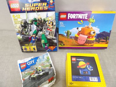 Trois Lego sont posés sur une table, à côté d'une boîte de Lego.