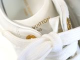 a close up of a pair of white shoes with gold buttons