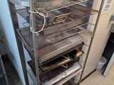 une photo d'une cuisine dans laquelle se trouve une étagère sur laquelle sont posées des casseroles et des poêles