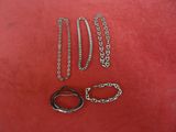 three pairs of scissors and a chain on a red surface