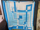 une écharpe bleue et blanche accrochée au mur à côté d'une chaise marron