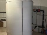 a large white tank in a room with a lot of pipes