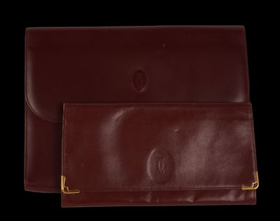 two brown leather wallets on a black background