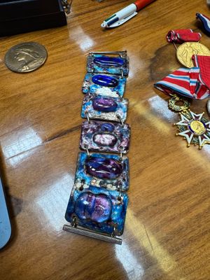 a wooden table topped with medals and a cell phone