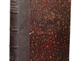 un vieux livre posé sur une table recouverte de fleurs rouges et marron