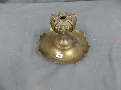 a gold candle holder on a table with a label on it