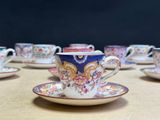 many cups and saucers sitting on a table