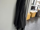 a black coat hanging on the wall next to a door