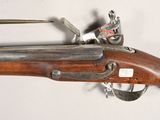 an old rifle with a wooden barrel and a metal handle