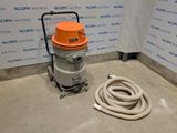 Une image représentant un aspirateur est posée sur le sol, à côté d'un tuyau