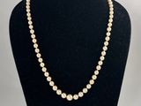 un collier de perles blanches sur un mannequin noir