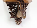 a goat head mounted on the wall of a wooden clock