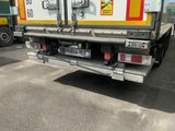 un camion qui est garé sur un terrain avec d'autres camions