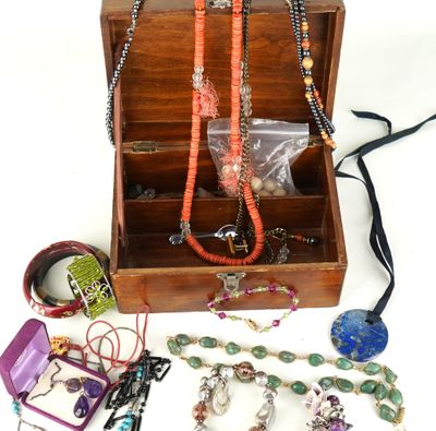 une boîte en bois remplie d'un assortiment de colliers et de bracelets
