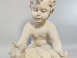 a small statue of a child with a teddy bear