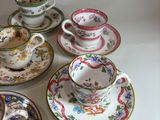 many cups and saucers sitting on a table