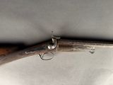 an old gun with a wooden handle on a white surface
