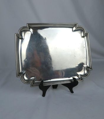 a silver tray with a handle on a stand on a white background