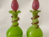 deux vases verts ornés de fleurs roses sur fond blanc