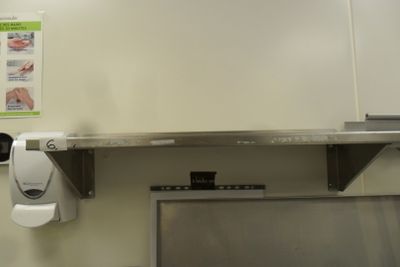a hand towel dispenser on the wall above a sink