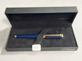 un stylo bleu dans une boîte noire posée sur une table blanche