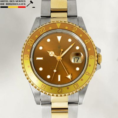 a gold and silver wrist watch with a yellow face