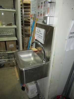 a stainless steel sink in the corner of a room