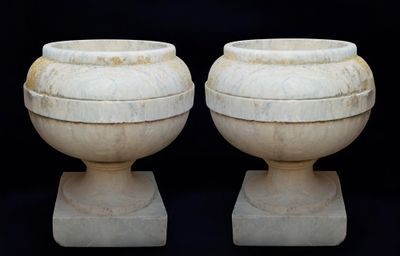two white vases sitting next to each other on a black background