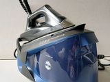a blue and black steam iron sitting on a counter