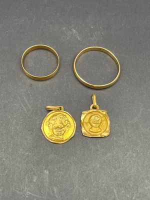 deux bagues en or et une pièce d'or posées sur une table