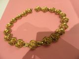 gold plated bracelet on pink background with shadow of a person