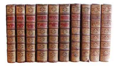 plusieurs vieux livres sont alignés sur une surface blanche