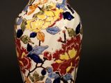 un vase orné de fleurs peintes sur fond noir