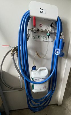 a blue hose attached to the wall next to a canister of water