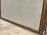 a large mirror sitting on the floor next to a wall