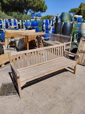a wooden bench sitting in the middle of a lot of barrels