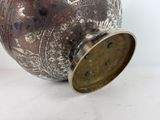 a silver vase sitting on a table with a lid